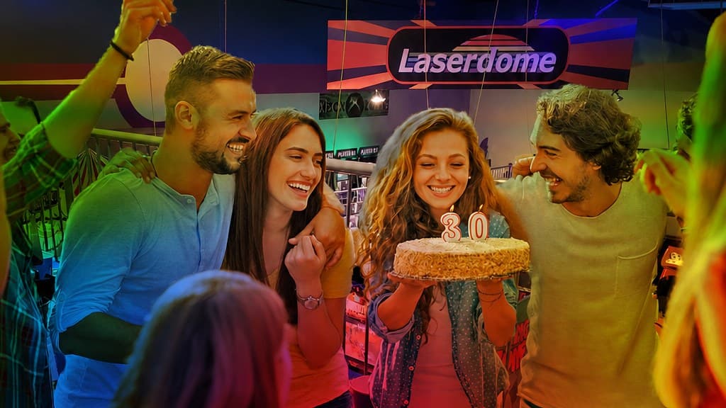 Adults celebrating a 30th birthday with cake at Laserdome