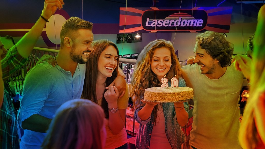 Adults celebrating a 30th birthday with cake at Laserdome