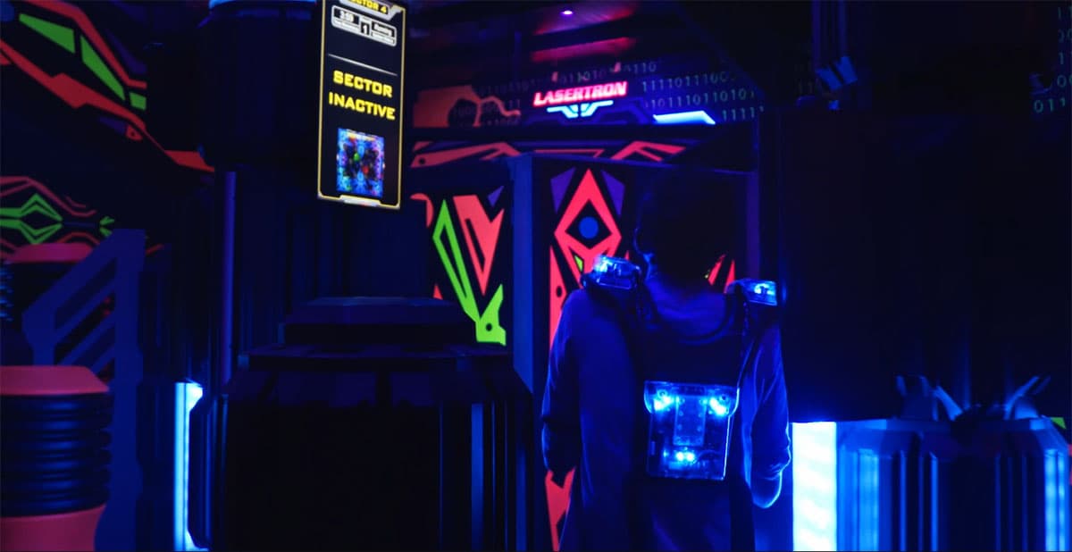 Player in Lasertron gear facing Sector 4 in the neon arena